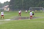 Fußballspiel auf einem überschwemmten Platz