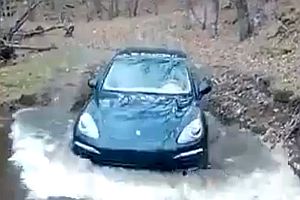 Porsche Cayenne fährt durch einen Fluss