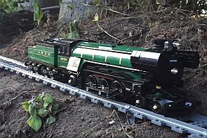 Lego-Eisenbahn fährt durch Haus und Garten