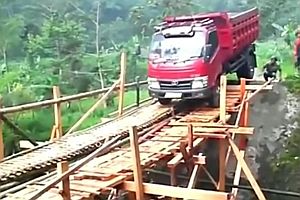 Lastwagen überquert Holzbrücke