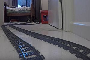 Lego-Eisenbahn fährt durch Garten und Haus