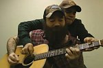 Zwei Männer spielen auf einer Gitarre
