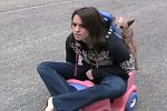 Ein Hund schiebt Frauchen im Kinderauto